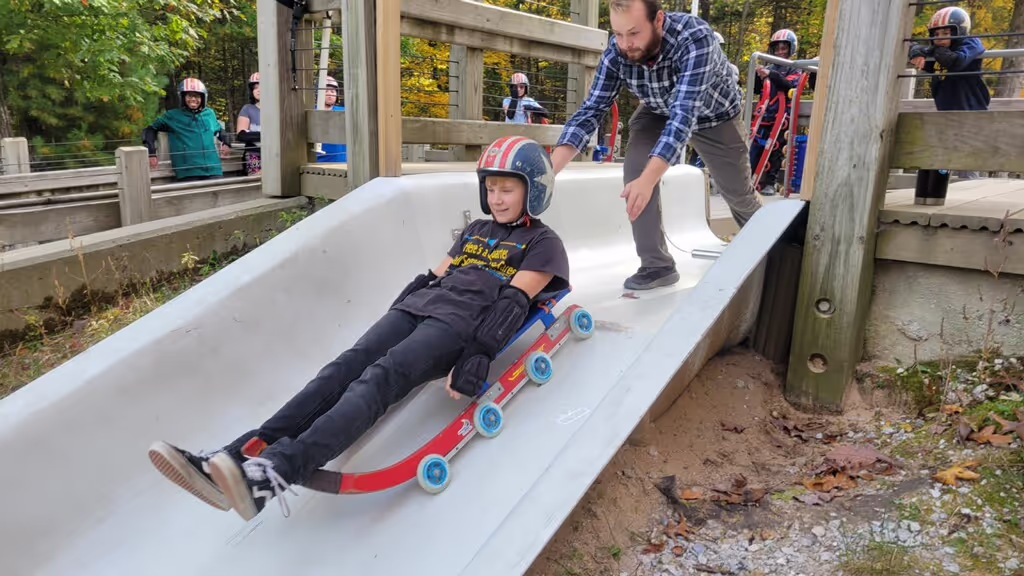 A student riding on a luge track